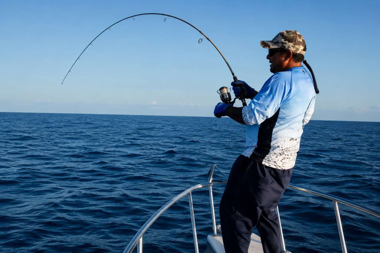 Angler fighting a large fish during a shared deep-sea fishing trip in Fuerteventura