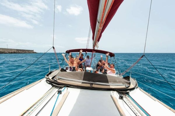 Happy group with hands raised on a private sailing boat trip from Morro Jable, Fuerteventura