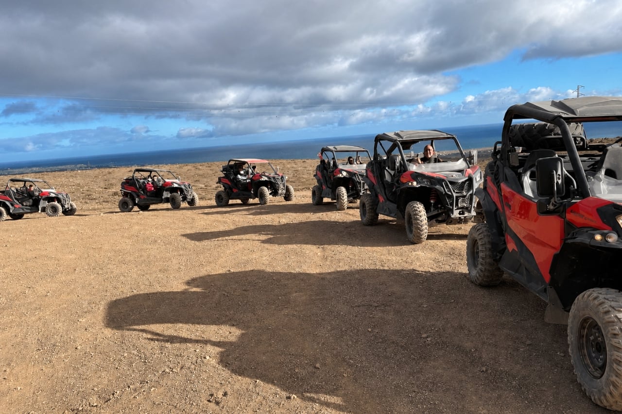 Black and red off-road buggy parked on rocky terrain overlooking the Atlantic Ocean in Lanzarote