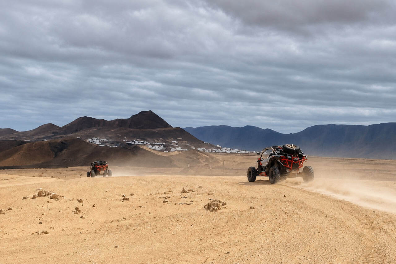 Two buggies driving through the dusty volcanic landscape