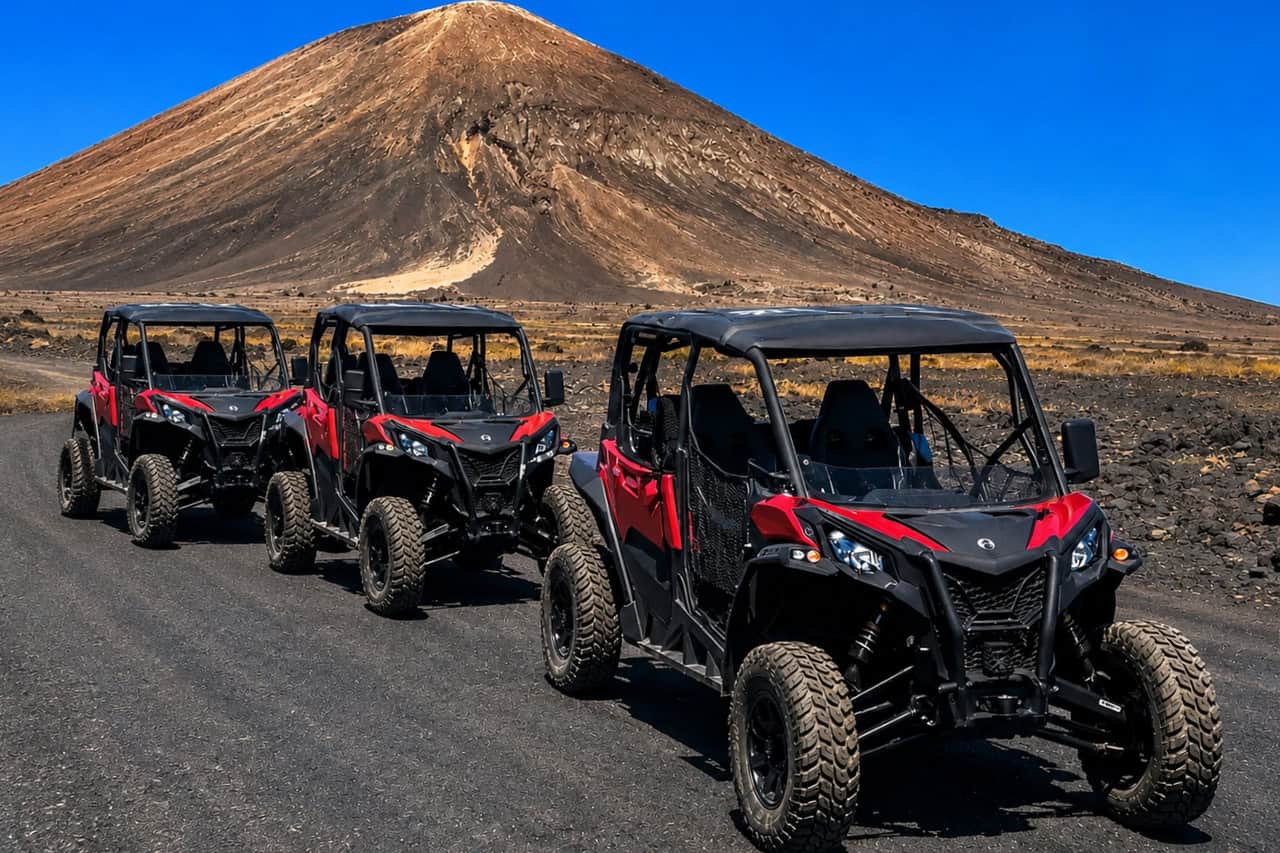 Buggy convoy parked in front of a volcanic mountain