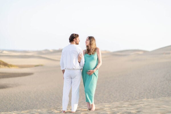 Pregnant couple embracing during a maternity session in Maspalomas dunes, Gran Canaria