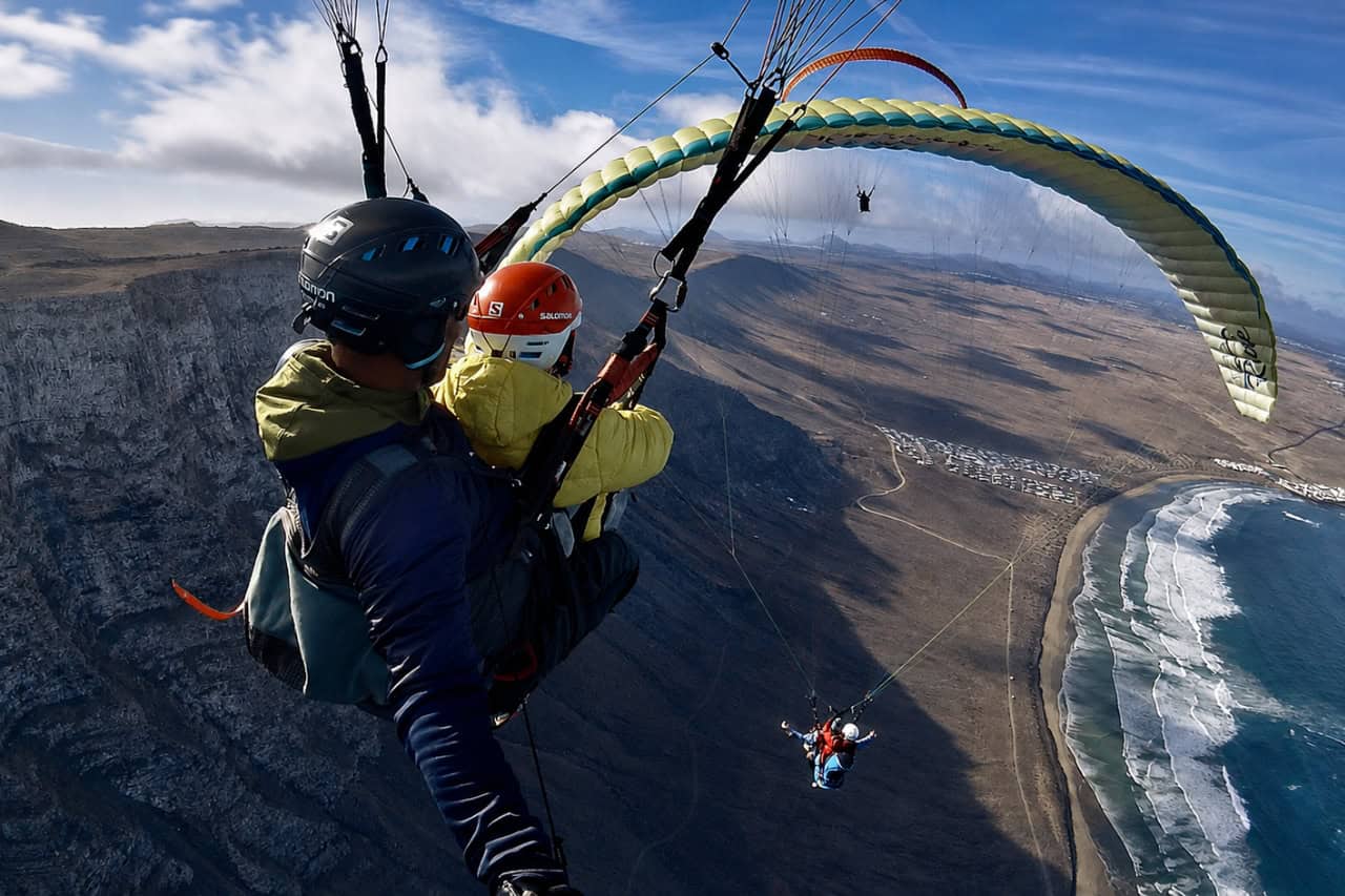 Tandem paragliding flight over the volcanic coast of Lanzarote