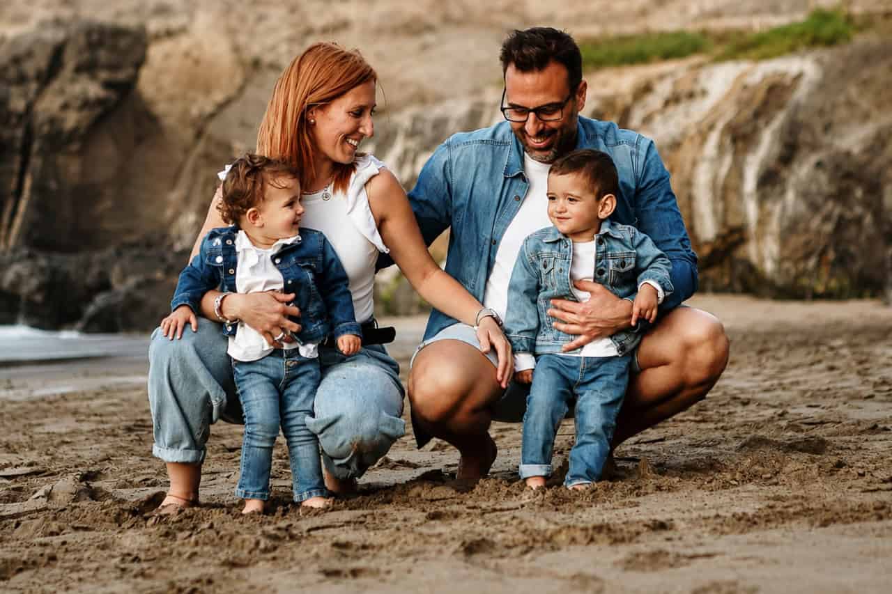 Parents with two children during a family photoshoot on the beach