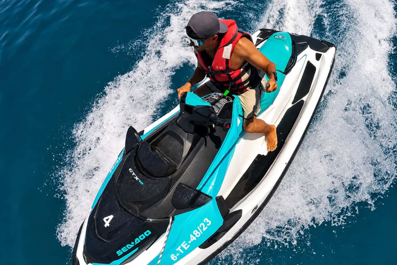 Rider on a turquoise Sea-Doo jet ski at speed in clear water in Fuerteventura