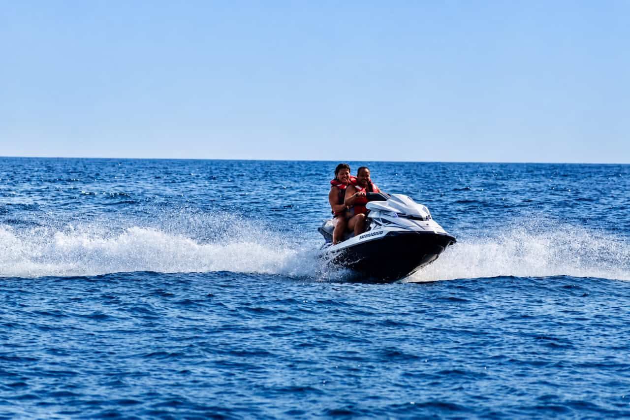 Two riders speeding across the Atlantic near Fuerteventura with a trail of spray