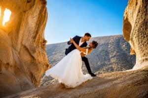 Newlywed couple embracing among dramatic volcanic rock formations during a wedding photoshoot in Fuerteventura.