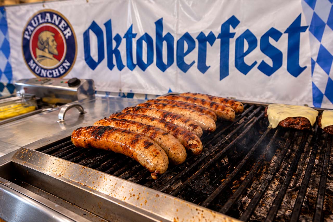 Grătarul de Bratwurst la Oktoberfest Tenerife, unul dintre preparatele germane clasice pe care vizitatorii le pot savura de la standurile festivalului, alături de bere și alte preparate tradiționale.