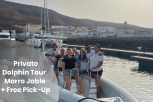 Turistas felices en una excursión privada en barco con delfines en el puerto de Morro Jable