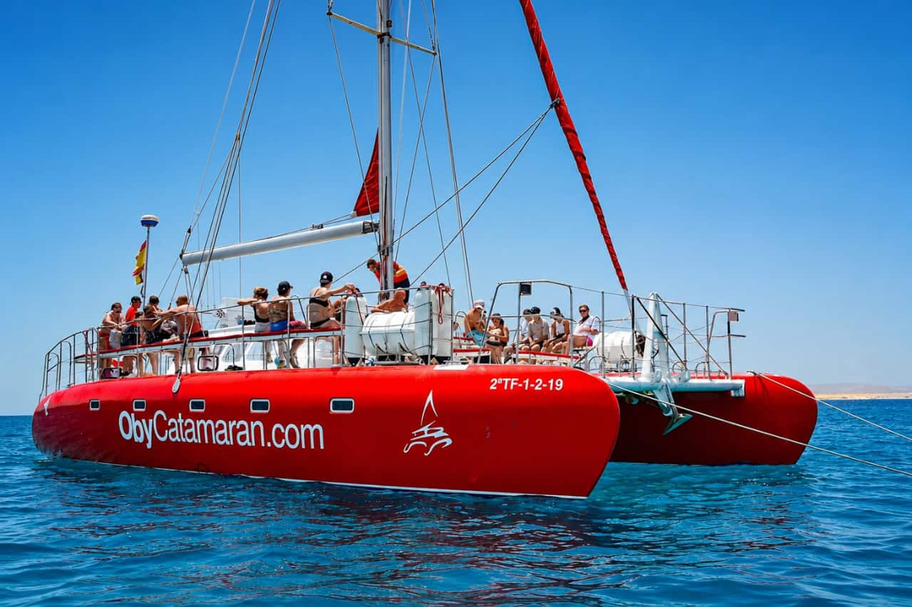 Red catamaran sailing across the Atlantic during a boat party in Fuerteventura