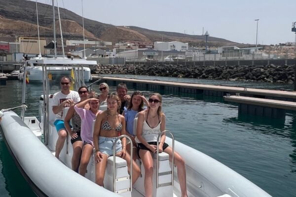 Pequeño grupo disfrutando de una excursión privada en barco con delfines cerca del puerto de Morro Jable