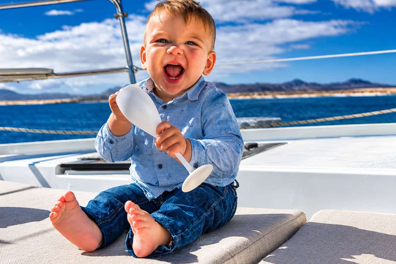 Smiling baby on board during a family catamaran charter in Fuerteventura