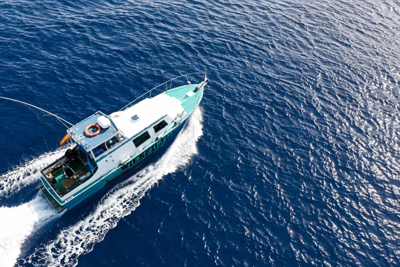Aerial view of the Wicked Tuna fishing boat cruising across the Atlantic Ocean near Lanzarote and leaving a white wake behind it.
