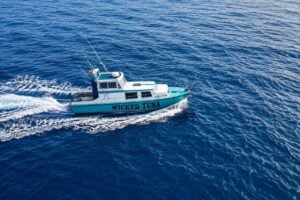 Wicked Tuna fishing boat cruising across the Atlantic Ocean near Lanzarote, leaving a white wake behind it.