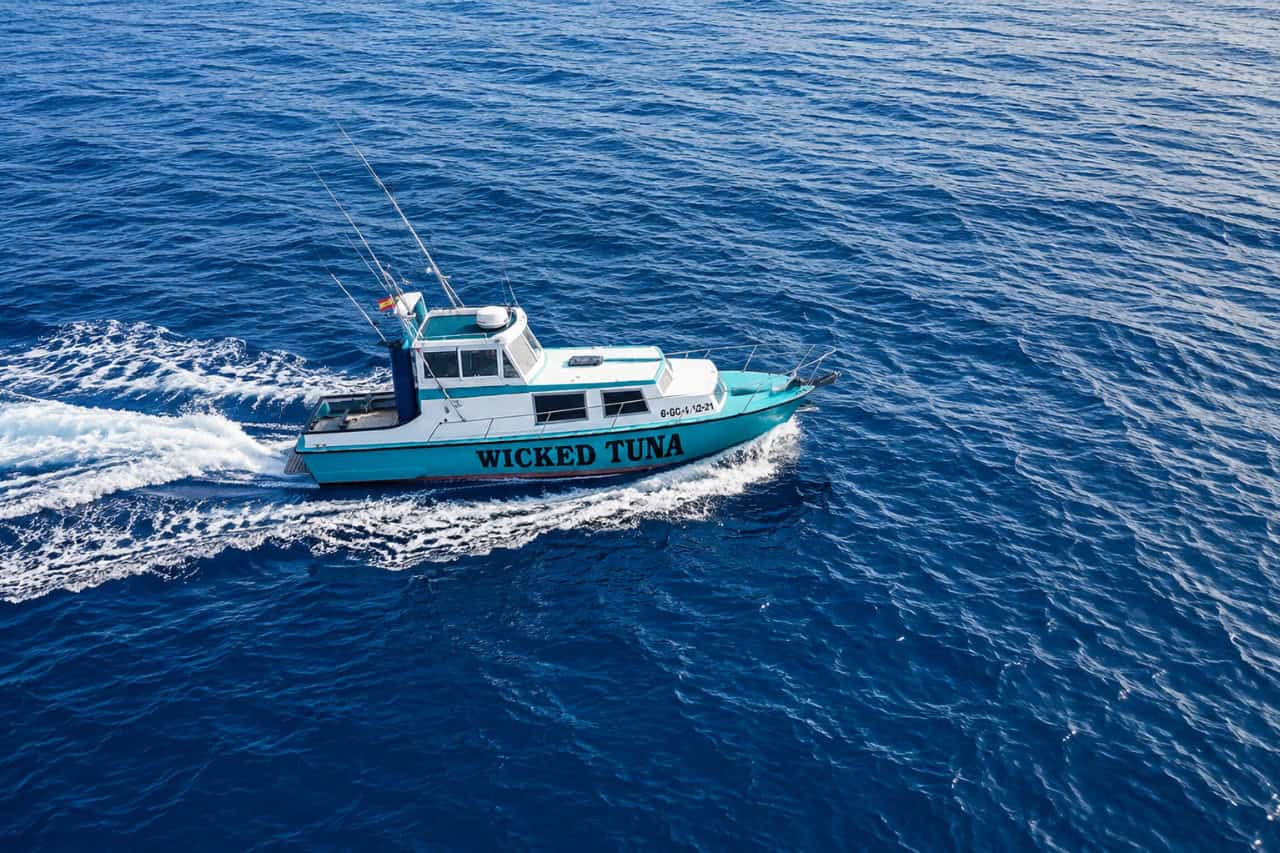 Wicked Tuna fishing boat cruising across the Atlantic Ocean near Lanzarote, leaving a white wake behind it.