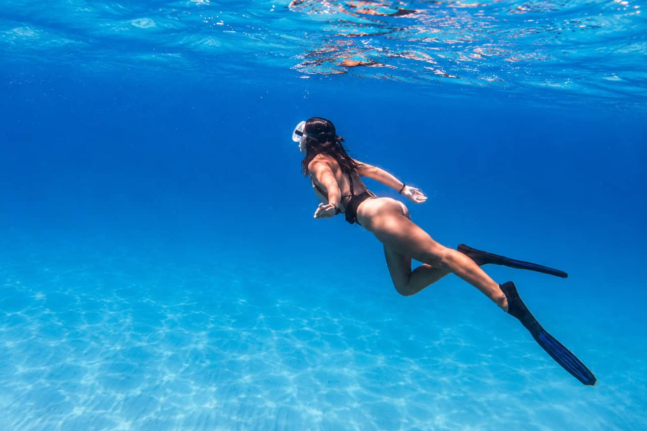 Woman snorkelling in clear blue Atlantic water during a sailing trip in Fuerteventura.