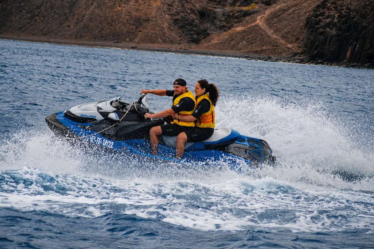 Couple riding a jet ski at speed in Lanzarote