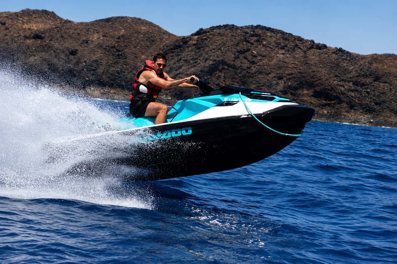 Rider speeding along the volcanic coast of Lanzarote on a jet ski