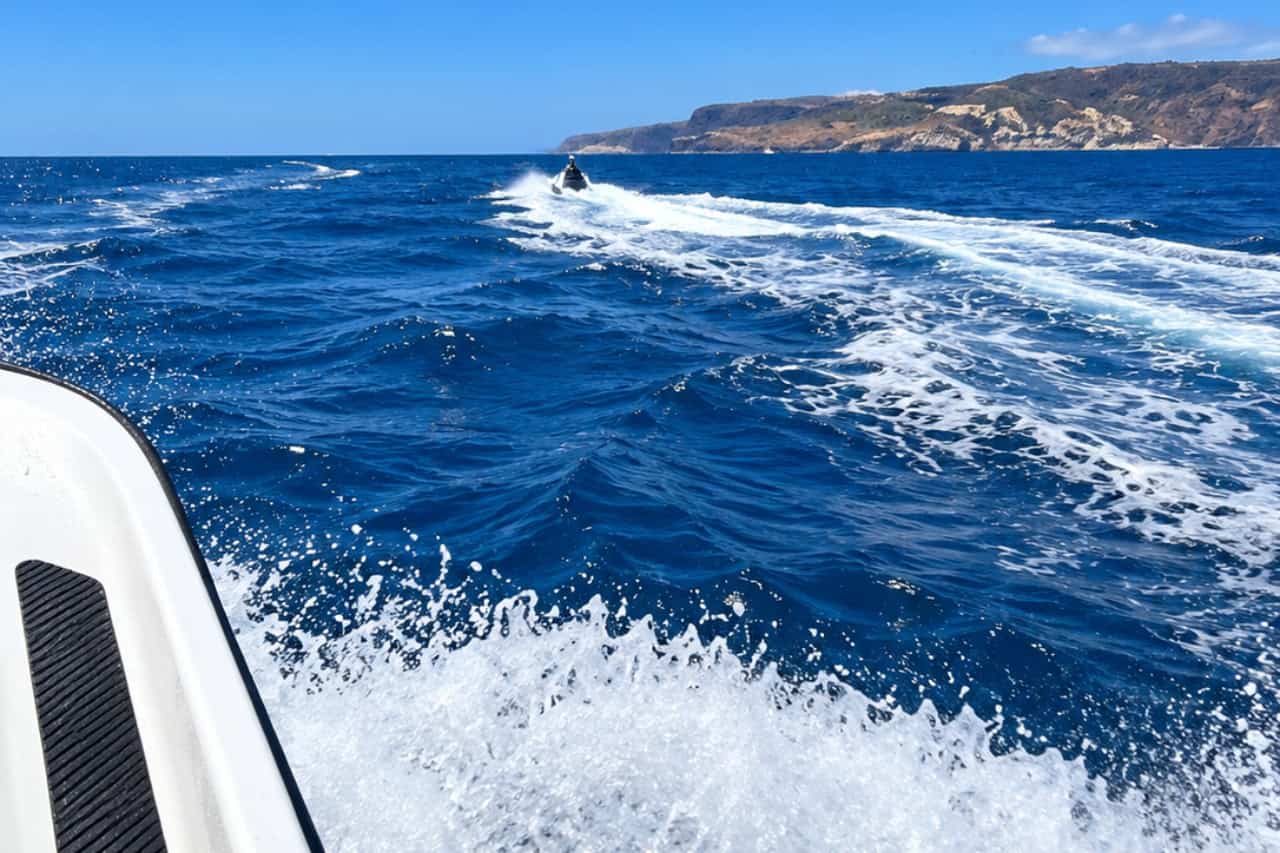 A jet ski riding ahead, seen from the safety boat