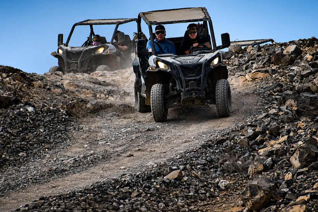 Two buggies descending a rugged rocky trail during an off-road tour in Fuerteventura.