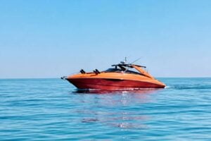 Orange Sunseeker motor yacht cruising on calm blue water during a luxury boat trip in Lanzarote.