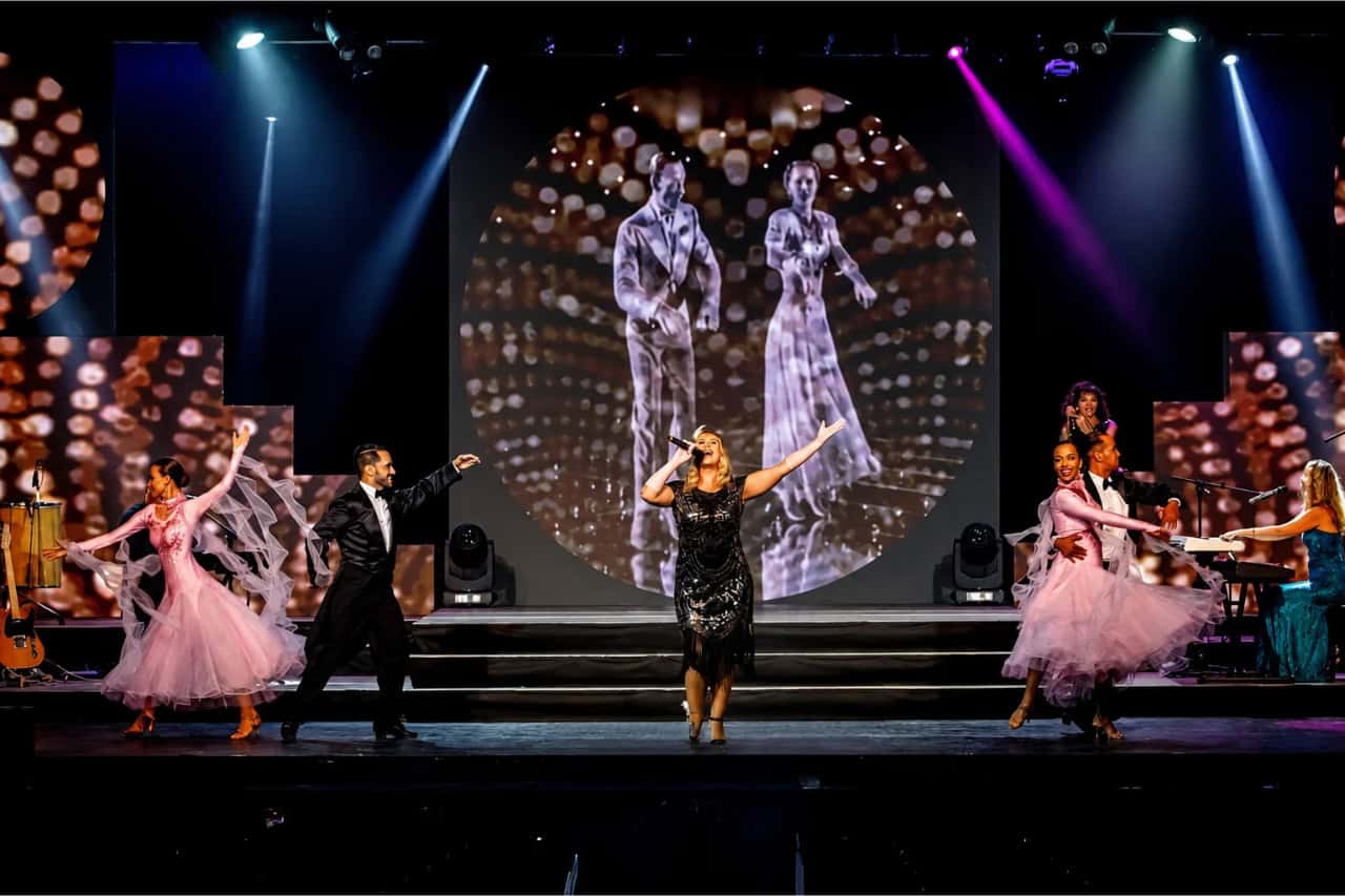 Dancers performing in front of a dramatic illuminated backdrop at a Tenerife evening show