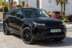 Svart Range Rover Evoque för uthyrning på Teneriffa visad från framsidan i trekvartsvinkel med svarta lättmetallfälgar, LED-strålkastare, glanssvart kaross, tonade rutor och förstklassig SUV-styling som lämpar sig för att köra runt på Teneriffa och Kanarieöarna.