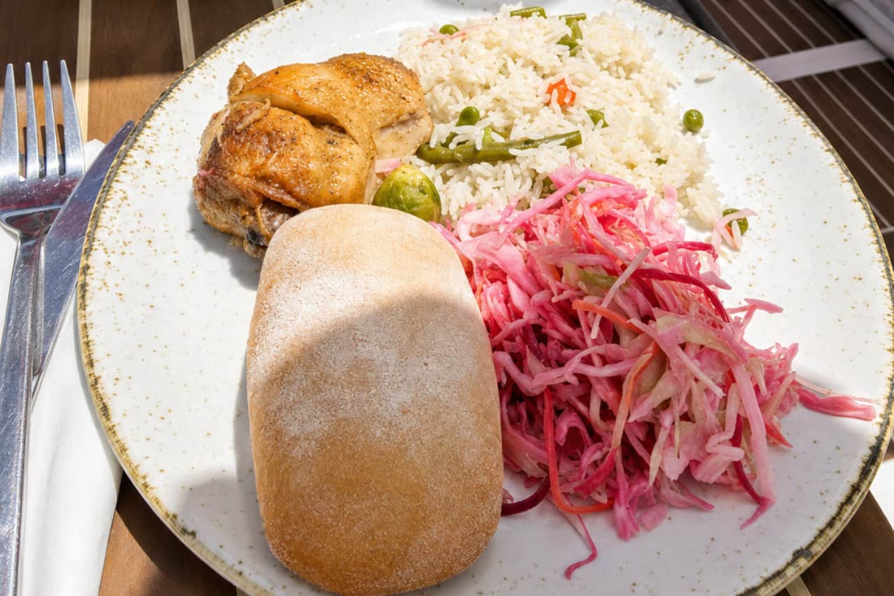 Chicken, rice, salad and bread served during a private Opera 60 boat charter in Tenerife