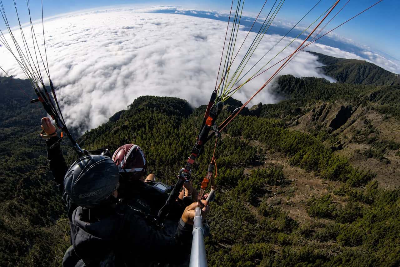 Tandem paragliding high above the mountains and clouds in Tenerife