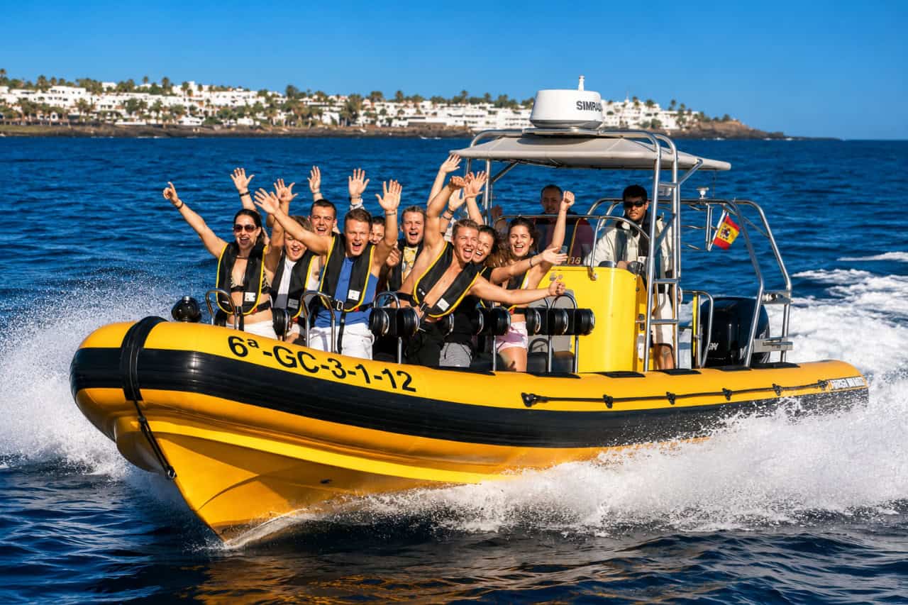 ellow speedboat carrying passengers across the ocean during a dolphin safari in Lanzarote.
