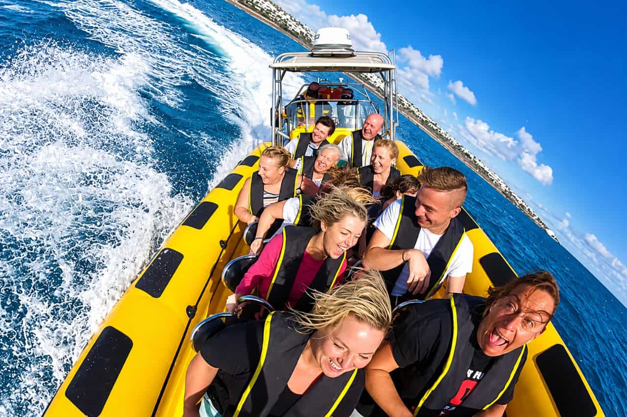 Group of passengers wearing life jackets enjoying a high-speed boat adventure off the coast of Lanzarote.