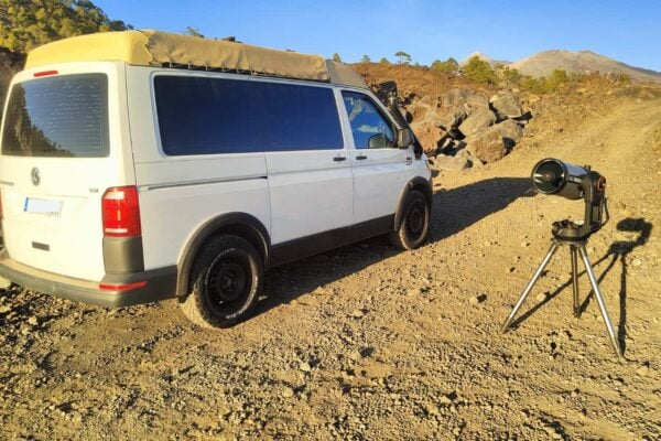 Minivan Volkswagen blanc à côté d'un télescope à Ténérife, transport pour des excursions d'observation des étoiles en groupe sur Mount Teide.