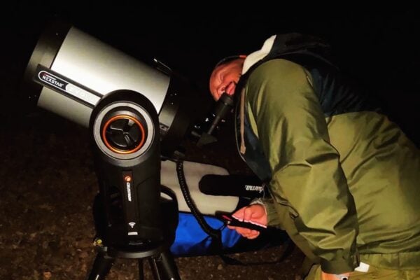 Invitat care observă cerul nopții cu ajutorul unui telescop în cadrul unui tur privat de observare a stelelor Teide