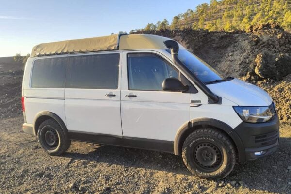 Microbuz alb parcat pe un teren vulcanic în Tenerife, folosit ca punct de întâlnire pentru excursii de observare a stelelor.
