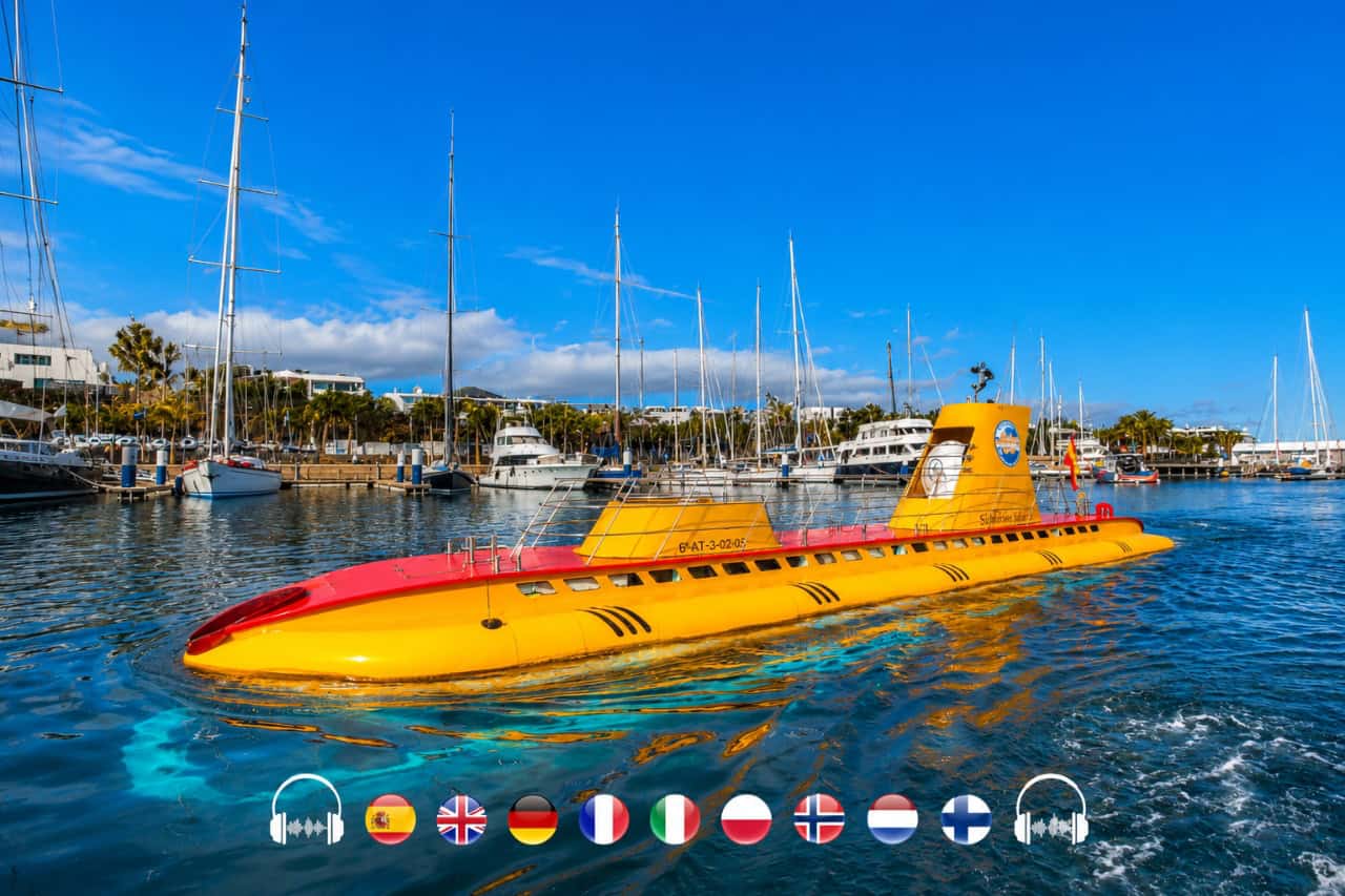Yellow tourist submarine floating in a marina surrounded by sailing boats in Lanzarote.