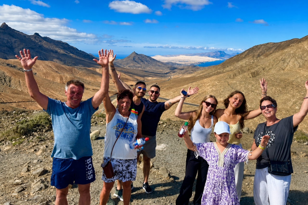 Small tour group celebrating at a mountain viewpoint over Fuerteventura