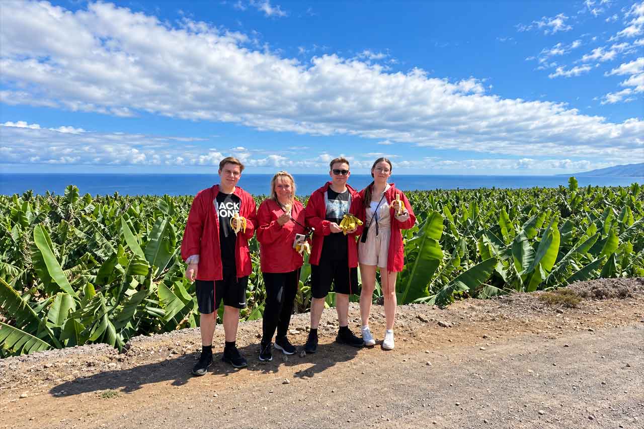 A group of guests enjoys the banana farm stop overlooking the Atlantic Ocean, part of the three-hour North Coast buggy route through the countryside around Puerto de la Cruz.
