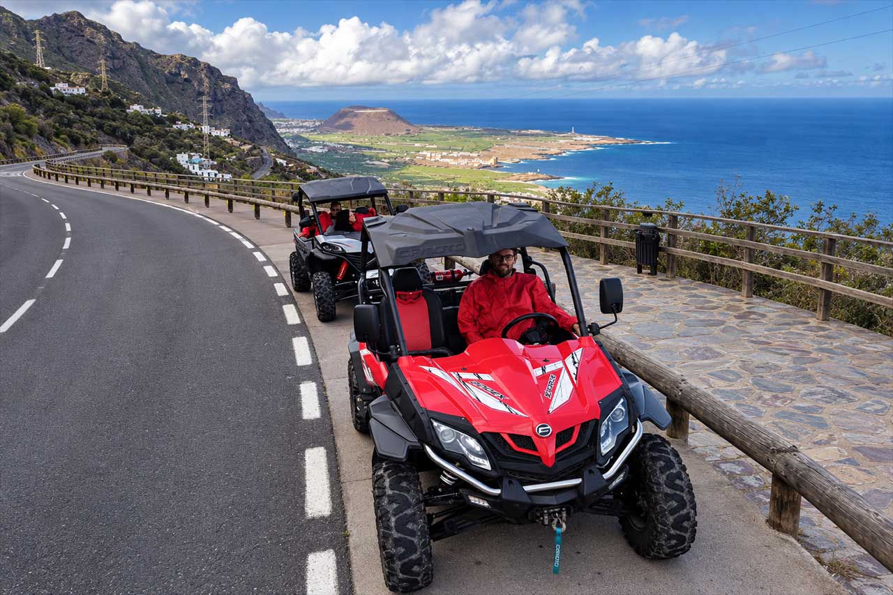 Buggies stop beside a mountain road with panoramic views over Tenerife’s green northern coastline and Atlantic Ocean, capturing the scenic viewpoint experience included during the Puerto de la Cruz buggy adventure.