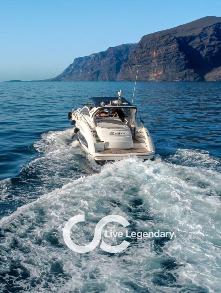 Private yacht cruising in Los Gigantes with the famous Tenerife cliffs in the background during a private yacht trip