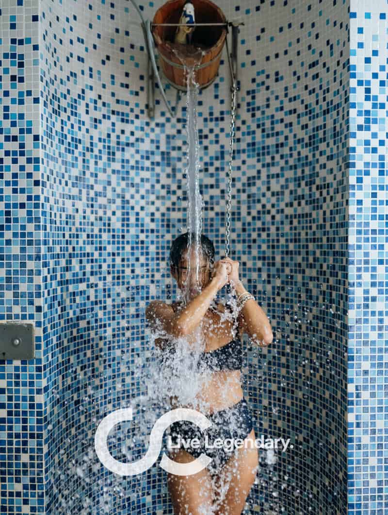 Woman under cold bucket shower at thermal spa Aqua Club Termal Tenerife