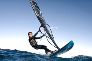 Windsurf Tenerife – Simona purjelautailemassa vauhdikkaasti aallokossa El Médanossa; toimintaotoksesta varausnumero Club Canary