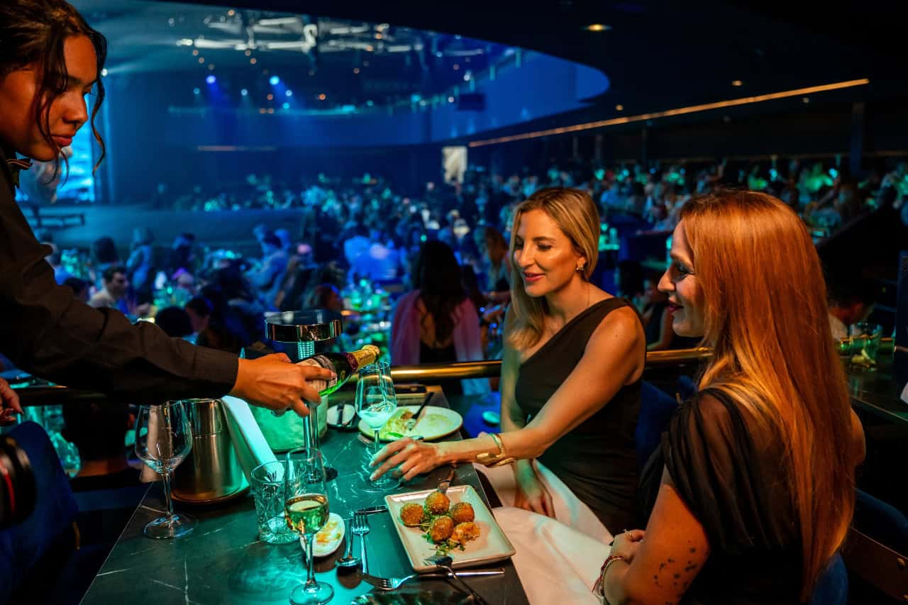 Guests being served drinks during dinner at the Nomad show in Gran Canaria