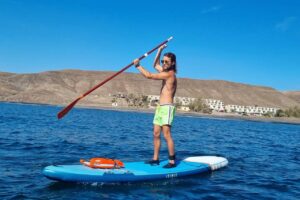 Man paddle boarding near the coast of Fuerteventura, booked with Club Canary