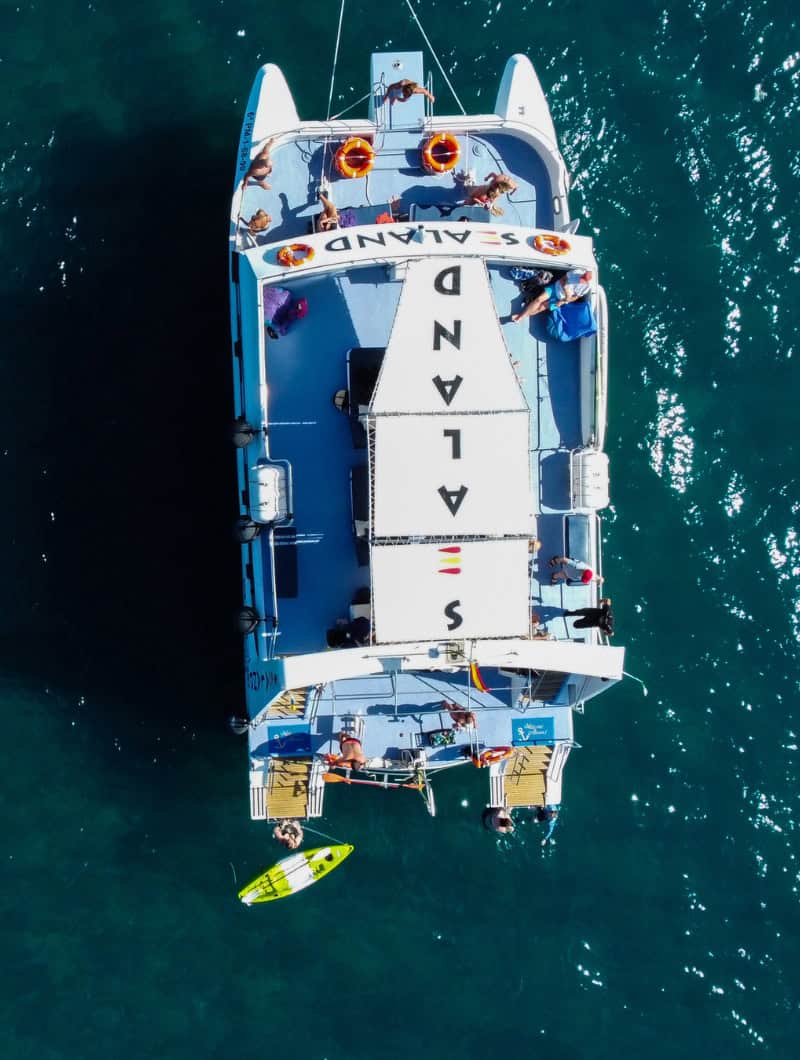 Private premium Sealand catamaran sailing from Gran Tarajal harbour with the town and cliffs behind, Fuerteventura