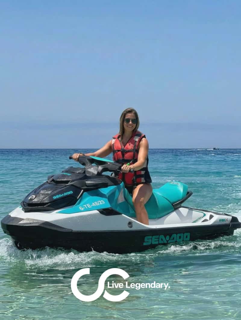 Nainen istuu turkoosilla Sea-Doo-vesiskootterilla kirkkaassa matalassa vedessä Morro Jablessa, Fuerteventuralla, Live Legendary