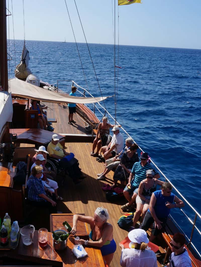 Guests relaxing on the wooden deck of the Shogun boat tour Tenerife, booked with Club Canary