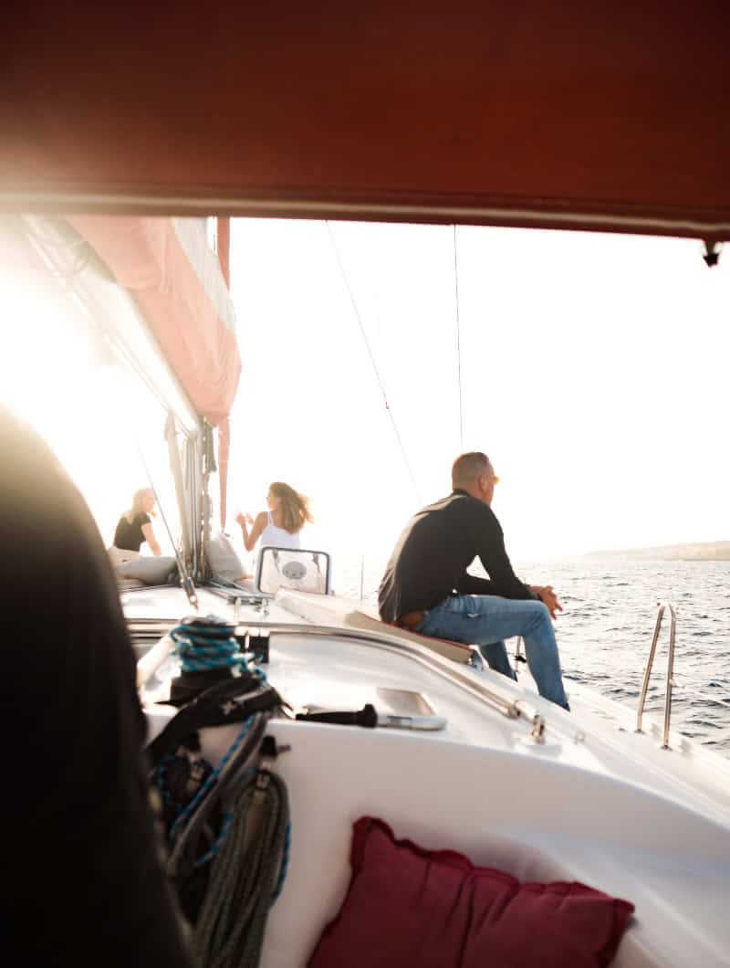 Guest relaxing on the deck of a small group whale watching sailing boat in Tenerife while heading out to find whales