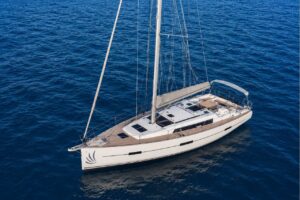 Aerial view of a 12.4-metre premium sailing yacht cruising across the clear blue waters of Tenerife, showcasing its modern design and spacious deck.