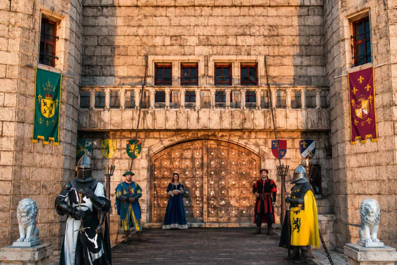 Medieval knights and royal court members welcoming guests at the castle entrance of the Medieval Adventure Dinner Show in Tenerife.