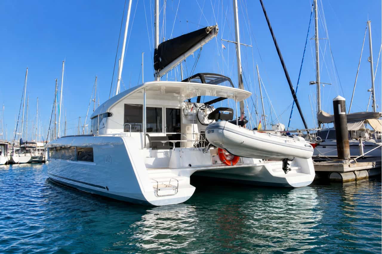 Modern luxury catamaran moored in a Tenerife marina, showcasing its spacious deck and premium design before a private sailing charter along the island's coast.